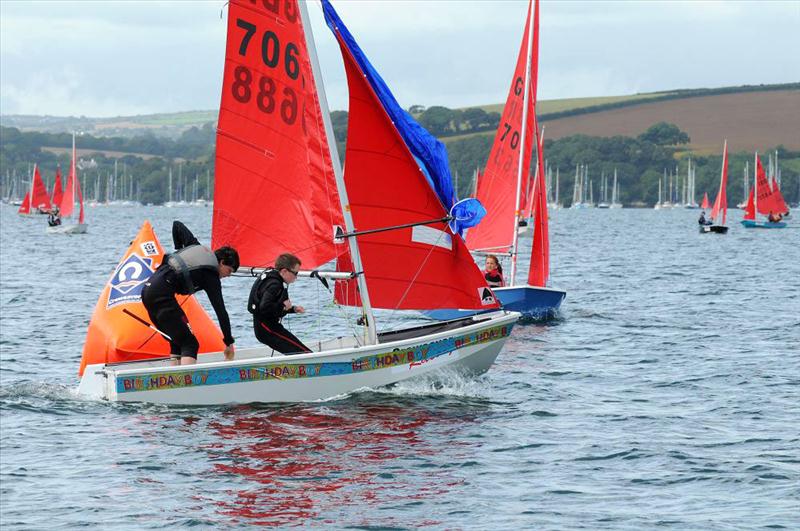 Mirror Dinghy rounding a windward mark and hoisting spinnaker